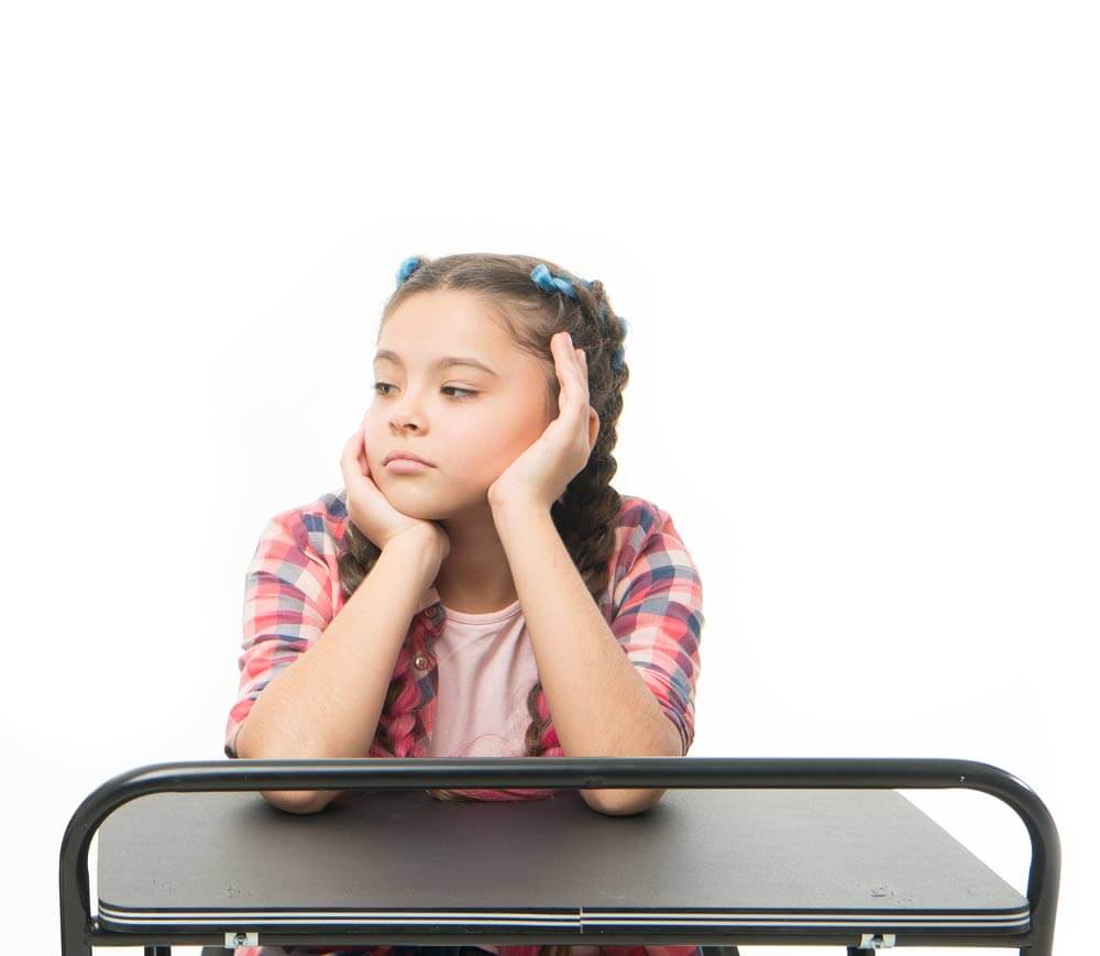 Girl looking bored sitting at a desk